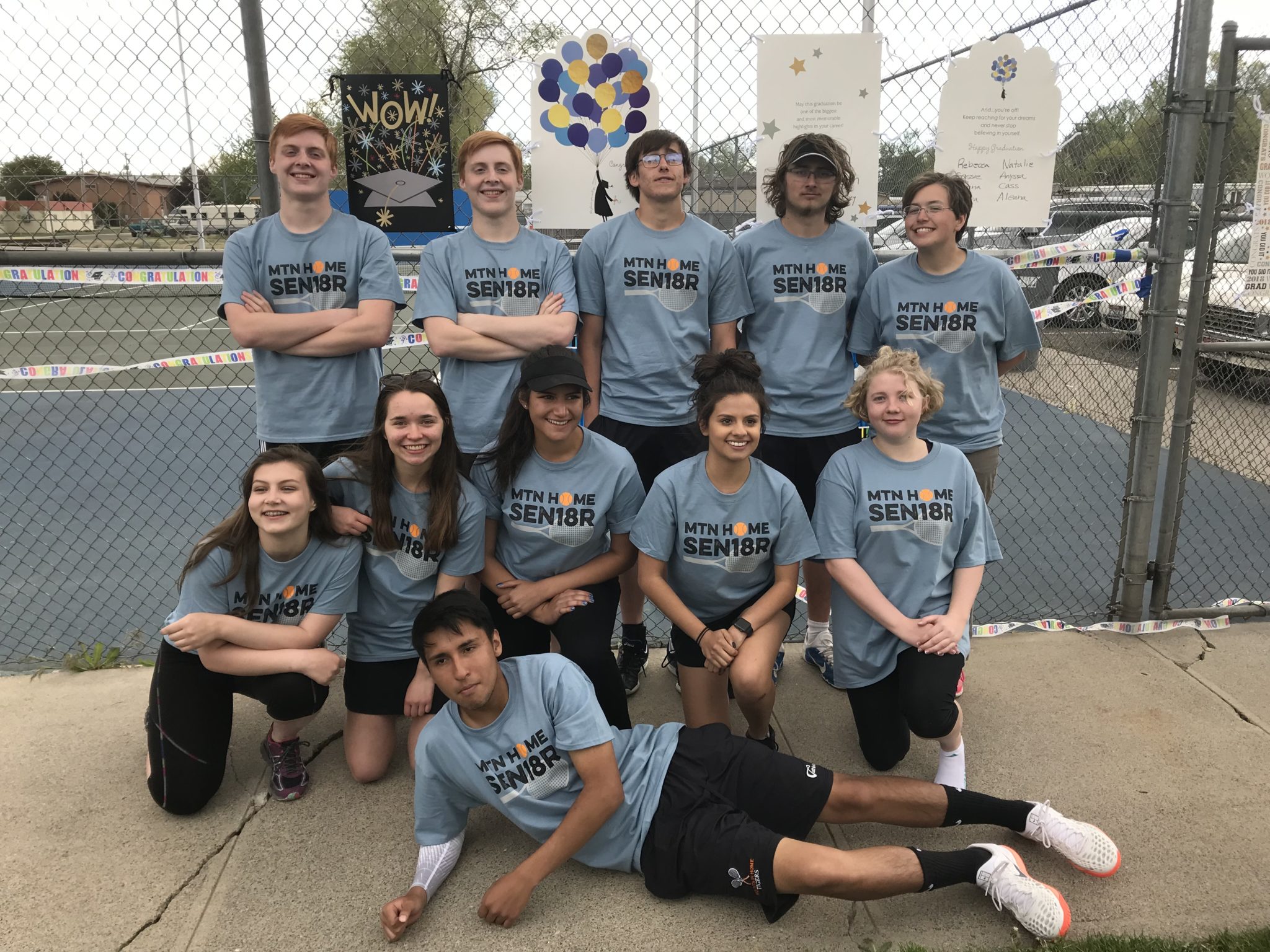 Group of high school seniors wearing matching custom shirts at their senior night celebration